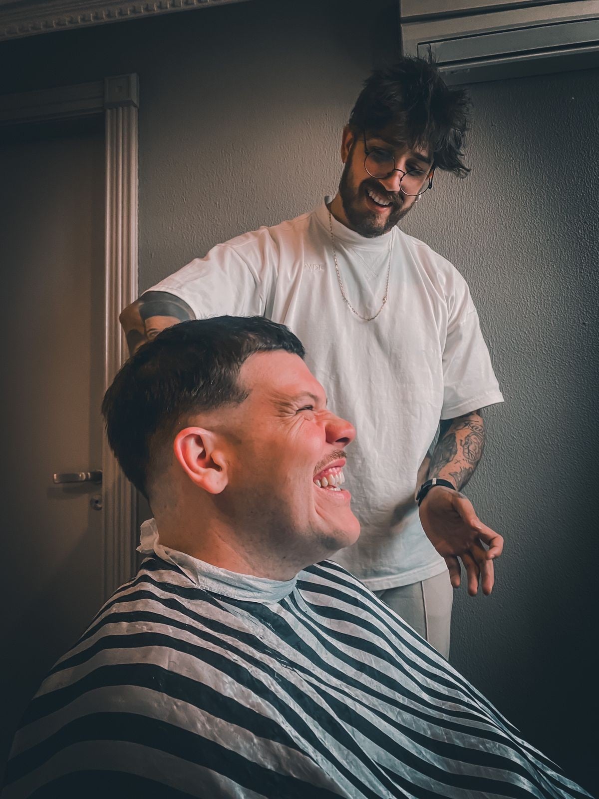 Cliente sorrindo durante o corte com André Padilha